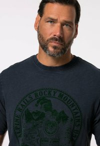 Námorně modré bavlněné tričko s zeleným grafickým potiskem parní lokomotivy a hor, s ribbovaným výstřihem a krátkými rukávy.