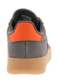 Gray suede sneaker with an orange accent at the heel, rubber sole, and soft lace-up design for comfort and support.