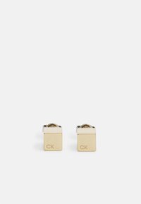Gemelli in oro e argento con design quadrato, incisi "CK", con finitura lucida e un dettaglio centrale circolare trasparente.