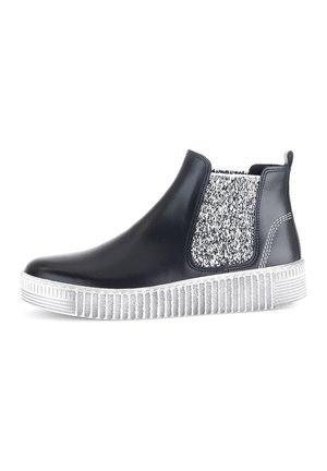 Zwarte chelsea boot van glad leer, met een getextureerd wit en zwart elastisch zijpaneel en een geribbelde witte rubberen zool.