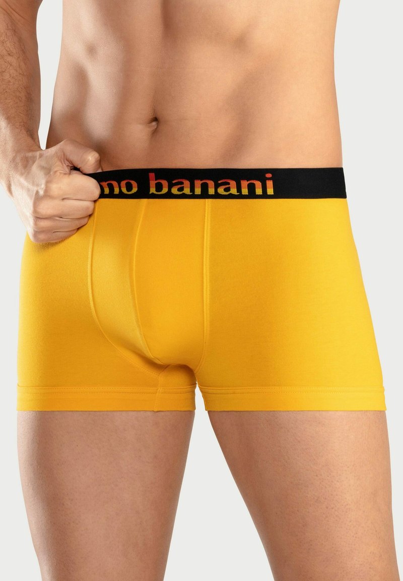 Yellow cotton boxer briefs with a black waistband featuring red text. The fabric appears smooth with a fitted design and short leg lengths.