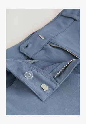 Blaue Wildlederhosen mit einem Reißverschluss, klarem Knopf und silbernem Zubehör. Glatte Textur mit genähten Details und Seitentaschen.