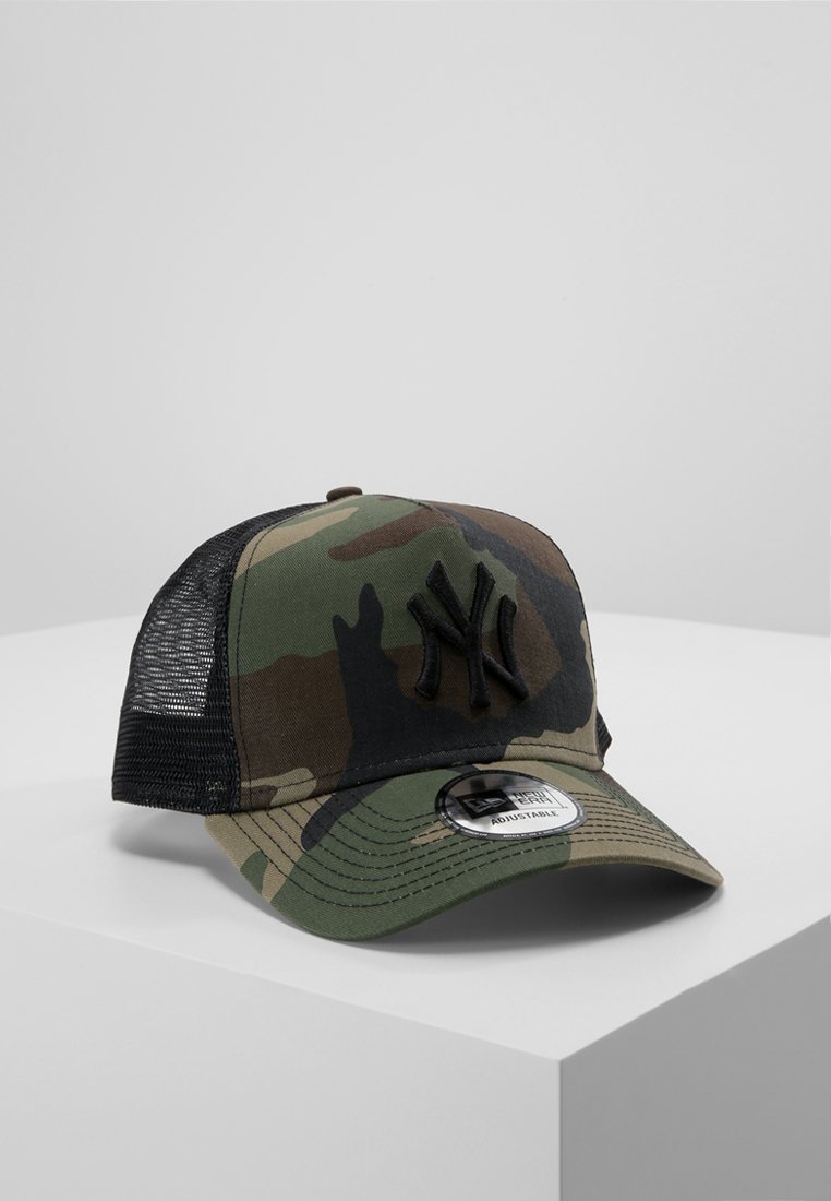 Camouflage-Kappe mit einem schwarzen bestickten Logo, Mesh-Rücken, gebogenem Schild und verstellbarem Riemen. Der Stoff ist eine Mischung aus grünen und braunen Farbtönen.