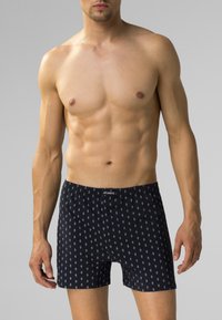 Spodenki bokserskie w granatowym kolorze z białym wzorem w diamenty. Wykonane z bawełny, z zapięciem na guziki i elastycznym pasem.