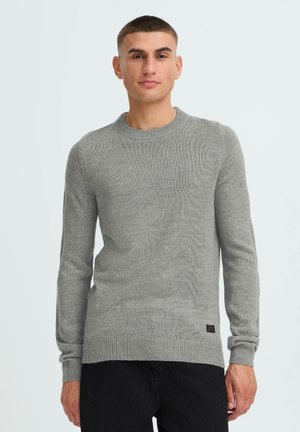 Hellgrauer Strickpullover mit rundem Ausschnitt, langen Ärmeln, gerippten Bündchen und Saum. Verfügt über eine subtile Textur und ein kleines Logo am unteren Rand.