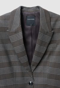 Braun kariertes Blazer mit hellgrauen Streifen, mit Revers, einstelligem Knopfverschluss und seidig glänzendem Innenfutter. Das Etikett zeigt die Marke "Calliope."