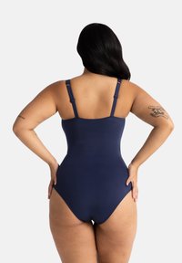 Temno moder enodelni kopalke z nastavljivimi naramnicami, visokim rezom in gladko, raztegljivo teksturo. Minimalistična zasnova brez okrasnih elementov.