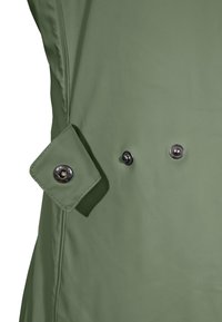 Green waterproof coat detail featuring a rectangular cuff with a snap button and two circular buttons for fastening. Smooth texture.