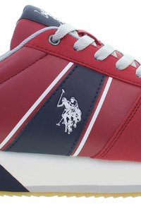 Czerwone i granatowe sneakersy z szarymi sznurówkami, skórzany cholewka, białe akcenty w postaci pasków oraz logo przedstawiające dwóch graczy polo po boku. Trójkątny wzór podeszwy.