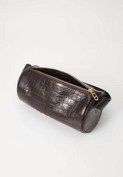 Hnedá kožená taška s krokodílím reliéfom, so zlatým zipsom a čiernou rúčkou. Má valcový tvar a textúrovaný povrch.
