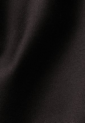 Gros plan d’un tissu noir texturé montrant un motif fin tissé avec la lumière et l’ombre créant de doux plis.