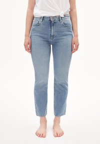 Ljusblå denimjeans med rak benmodell, fem fickor och medelhög midja. Minimalistisk design med en lätt urtvättning och solid sömnad.