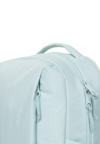 Mochila azul claro hecha de tela duradera, con cremalleras dobles, una superficie texturizada y un asa en la parte superior para un fácil transporte.