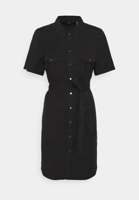 Svart skjortklänning med korta ärmar, två bröstfickor, midjebälte och en lätt rundad nederkant. Tillverkad av en enfärgad tyg utan mönster.