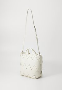 Borsa tote in pelle bianca con un motivo trapuntato a diamante, doppi manici superiori e una tracolla regolabile. Texture liscia.