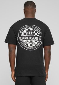 Svart bomull t-skjorte med hvit grafisk design på baksiden, som viser en diner-logo med et motiv av burger og pomfritter.