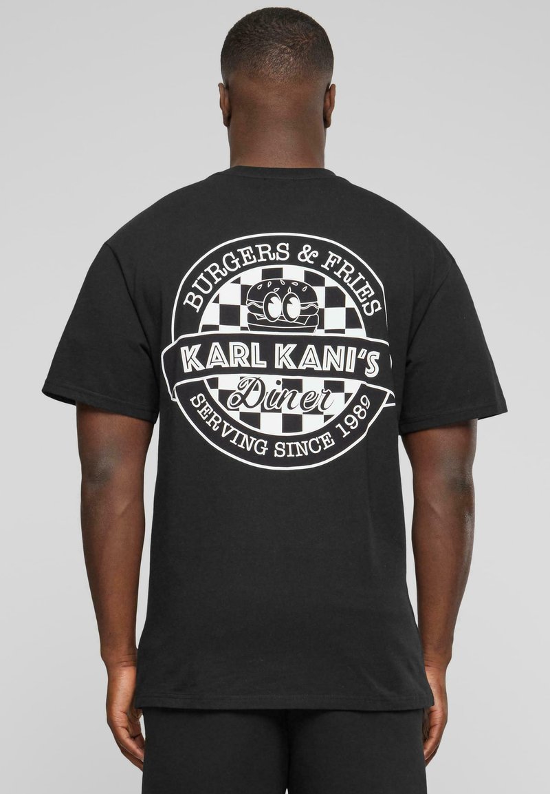 Svart bomull t-skjorte med hvit grafisk design på baksiden, som viser en diner-logo med et motiv av burger og pomfritter.