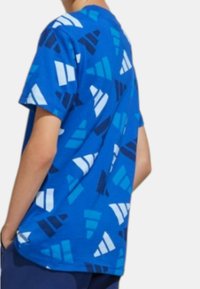 T-shirt azzurro a maniche corte con un motivo geometrico in diverse tonalità di blu e bianco, realizzato in tessuto di cotone.