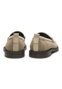 Beige Wildlederschuhe mit strukturiertem Finish, runder Form, Gummisohlen und kontrastierendem hellbeigem Band entlang der Rückseite und Ferse.