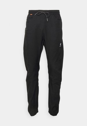 Pantalon de sport noir avec taille élastique et cordon de serrage, doté de poches latérales et d'un patch logo sur la jambe gauche. Texture lisse.