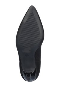 Zwarte puntige schoen met een gebreid bovenwerk, een gestructureerde zwarte rubberen zool en een glanzend zwart accent aan de achterkant. Maat 37 gemarkeerd op de zool.