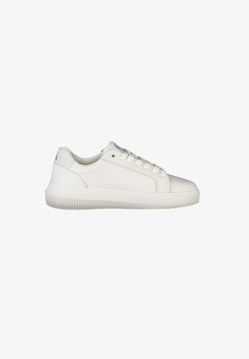 White leather sneakers feature a rounded toe, padded collar, flat laces, and a textured rubber sole with horizontal grooves.