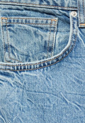 Hellblaue Denim-Jeans mit verblasster Textur, ausgestattet mit einer Gesäßtasche, kontrastierenden orangen Nähten und einem Metallschluss.