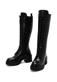 Botas de cuero negro hasta la rodilla con un diseño de cordones en la parte frontal, cremallera lateral y tacón grueso; acabado suave y suela robusta para mayor tracción.