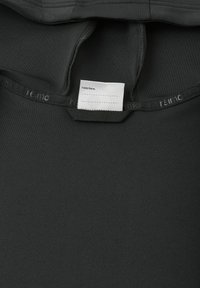 Maglietta atletica nera con una texture liscia, caratterizzata da un colletto rinforzato e un'etichetta con la scritta "Io ero qui" attaccata all'interno del colletto.