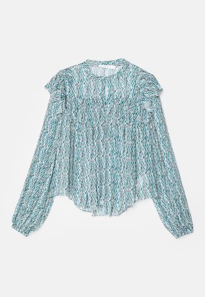 Blusa ligera en turquesa y blanco con un patrón de olas. Presenta hombros con volantes, mangas largas y un corte holgado con un dobladillo redondeado.