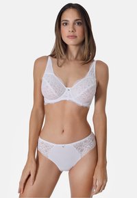 Weißer Spitzen-BH mit floralem Muster, breiten Trägern und einem kleinen zentralen Akzent. Passende weiße Spitzen- und Stoff-Unterwäsche mit seitlicher Verzierung.