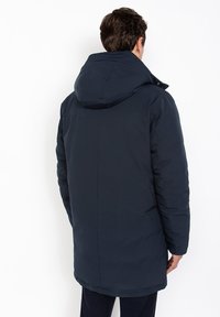 Chaqueta parka acolchada de color azul marino con capucha, con un corte recto y textura suave. Sin herrajes ni patrones visibles.