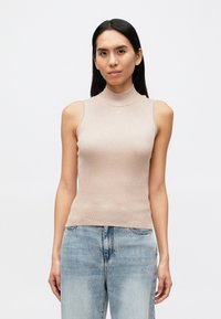 Bēša rūtainu piegriezumu bezroku topiņš ar augstu apkakli un piegulošu dizainu, izgatavots no viegla materiāla. Valdīta kopā ar gaiši zila džinsa biksēm.