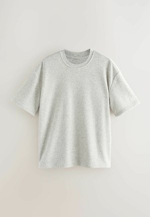 Šedé bavlněné tričko s krátkým rukávem a kulatým výstřihem, které má jemnou texturu a volný střih, bez jakýchkoli viditelných vzorů nebo grafik.