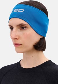 Blauwe sportieve hoofdband van rekbare stof, met een wit logo, een gladde textuur en een nauwsluitend ontwerp voor een veilige pasvorm tijdens activiteiten.