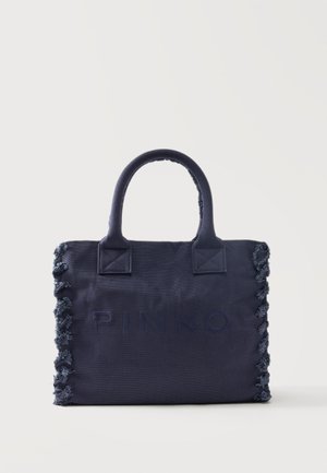 Bolso tote rectangular azul oscuro con asas cortas y bordes deshilachados en los lados, con el nombre de la marca en relieve sutil en el frente.