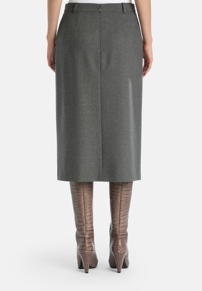 Grå ull pennkjol med en slits bak, matchad med knähöga bruna stiletto boots i croco-präglad läder med spetsiga tår.