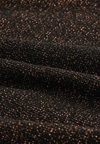 Čierna látka s textúrovaným povrchom, prepletená trblietavými medenými akcentmi, vytvárajúca jemný iskrivý efekt.