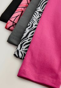 Cinq morceaux de tissu pliés : un rose vif, un noir avec un motif abstrait, un gris et un blanc avec des rayures de zèbre noires, montrant diverses textures.