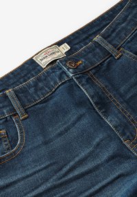 Donkerblauwe spijkerbroek van denim met oranje stiksels, een knoopsluiting en een merklabel op de tailleband. Beschikt over een klassieke vijf-pocketontwerp.