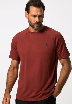 Bordeaux kortermig sportshirt met raglanmouwen, een ronde halslijn en een klein logo op de linkerborst. Glad stofmateriaal.