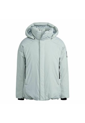 Jasnoszara puchowa kurtka o fakturowym wykończeniu, z kapturem i zamek błyskawiczny z przodu. Nałożona na jasnoszary hoodie z czarnym logo.