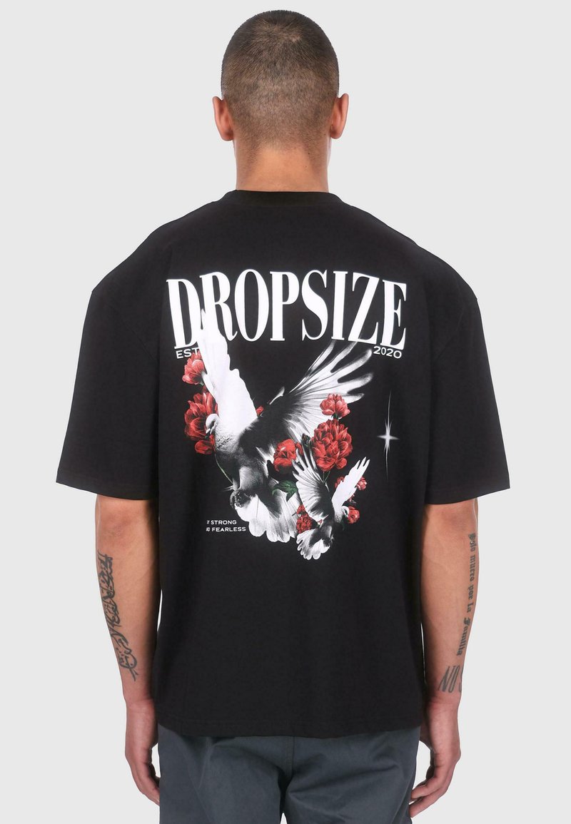 Black cotton t-shirt featuring a large graphic of white birds and red flowers on the back, with "DROPSIZE EST 2020" text above.