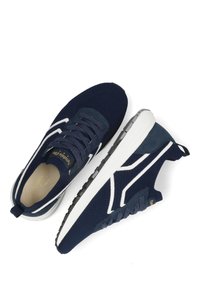 Marineblauwe sneakers met een gebreid bovenwerk, witte accenten en een gestructureerde zool. Beschikt over een vetersluiting en een lus aan de hiel.