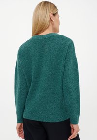 Teal groene trui gemaakt van zachte, gestructureerde stof; heeft een ronde hals en lange mouwen; ribgebreide zoom; ontspannen pasvorm.