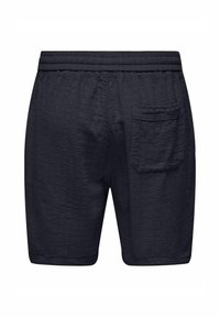 Pantalones cortos de color azul marino con textura, un cinturón elástico y un único bolsillo trasero de parche. La tela parece ligera y transpirable.