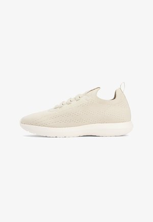 Beige knit sneaker with lace-up front, elastic ankle collar, pull tab at heel, and cushioned white sole.