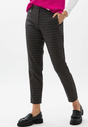 Pantaloni neri con un design geometrico, caratterizzati da una vestibilità slim e lunghezza alla caviglia. Abbinati a mocassini neri.