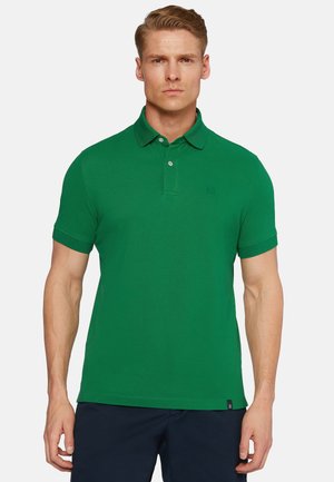 Grøn polo skjorte lavet af bomuldsblanding, med klassisk krave, korte ærmer og tre-knaps lukning. Har et diskret brandlogo.