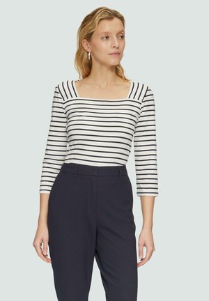 Gestreifte Langarmbluse mit quadratischem Ausschnitt, weißem Grund und marineblauen Streifen, kombiniert mit marineblauen, hochtaillierten Hosen. Weicher Stoff mit leichtem Glanz.